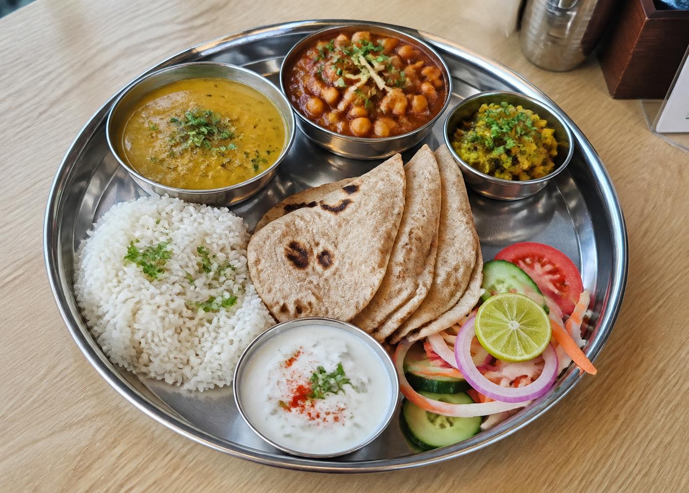 A full vegetarian thali with dal, chana masala, roti and rice